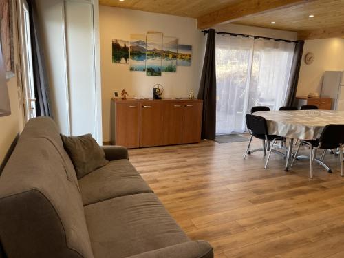a living room with a couch and a table at Gîte Belle Vue 2 in Saint-Léger-les-Mélèzes