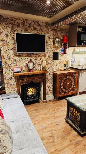 a living room with a fireplace and a television on a wall at Looking Glass Cottage in Brighton & Hove