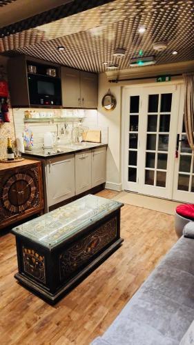 a kitchen with a table in the middle of a room at Looking Glass Cottage in Brighton & Hove
