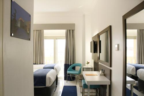 a hotel room with two beds and a table and chairs at Gloria Aqua Park Hotel in Aswan
