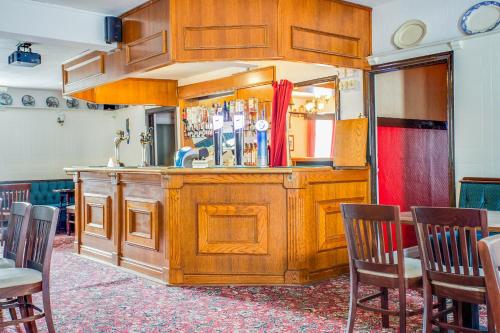 a bar in a room with chairs and a mirror at The Village Inn, Murton Seaham in Murton