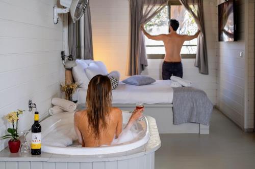 a woman sitting in a bath tub in a bedroom at Ein Zivan Village Resort in Ein Zivan