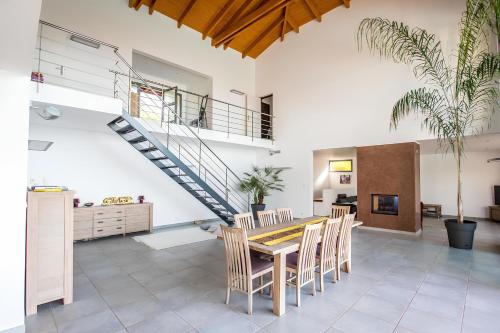 une salle à manger avec une table et des chaises et un escalier dans l'établissement DelSol - Villa Pool Gorgeous Sea view - by TGB, à Pietrosella