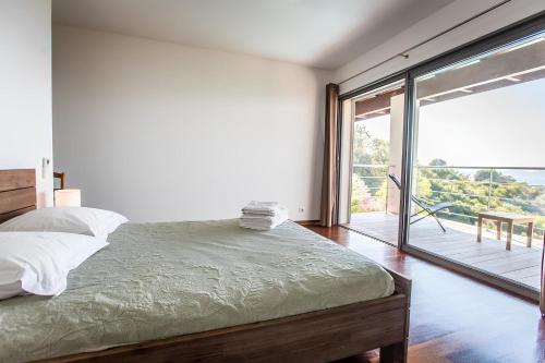 - une chambre avec un lit et une grande porte coulissante en verre dans l'établissement DelSol - Villa Pool Gorgeous Sea view - by TGB, à Pietrosella