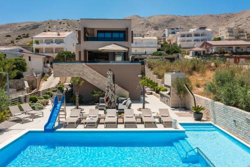 a villa with a swimming pool and a resort at Villa Emma on Island Pag for 14 persons with sea view, wellness & pool heating in Pag