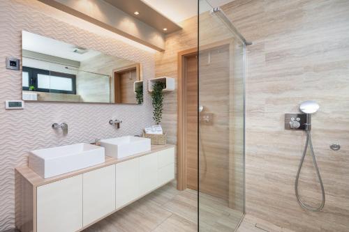 a bathroom with two sinks and a shower at Villa Emma on Island Pag for 14 persons with sea view, wellness & pool heating in Pag