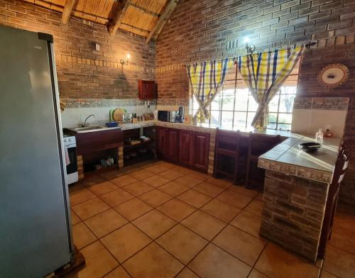 a large kitchen with a brick wall at Wayside Chalets in Tantebane