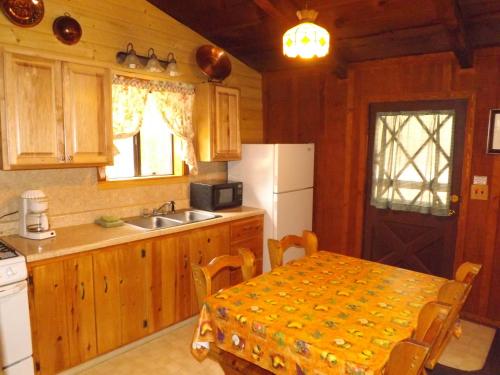 a kitchen with a table and a sink and a refrigerator at Arizona Mountain Inn & Cabins in Flagstaff