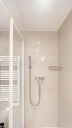 une douche avec une porte vitrée dans une salle de bain dans l'établissement La Bella Niçoise, à Nice