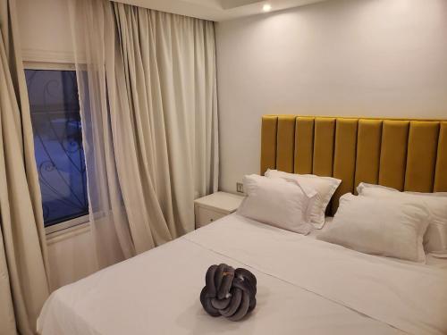 a bedroom with a large bed with white pillows and a window at luxury marsa beach 2 in La Marsa