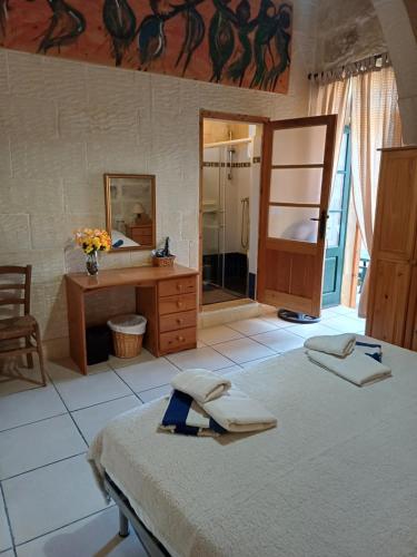 a bedroom with a bed and a sink and a mirror at Arkati house in Munxar