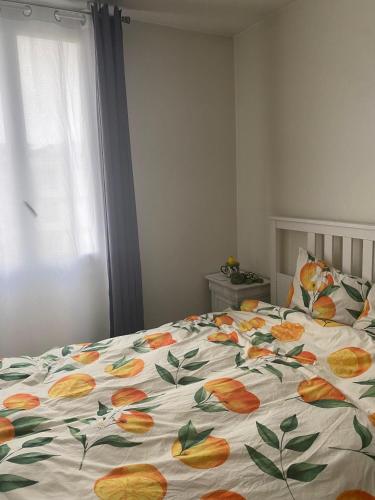 - un lit avec une couette à fleurs dans une chambre dans l'établissement Cosy T2 proche de l hyper centre de Grenoble, à Grenoble