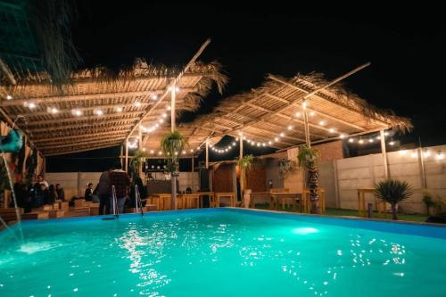 a swimming pool at night with lights on it at Casa Colpa Tiki in Chincha