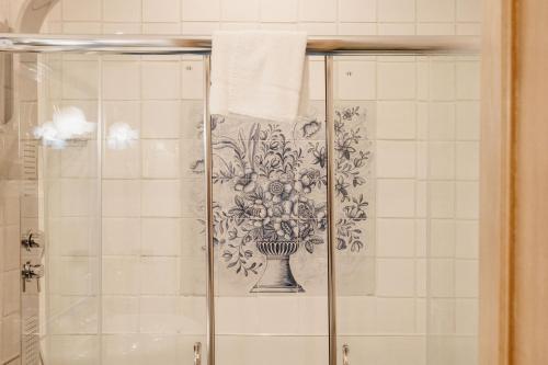a shower with a drawing of a vase on the wall at Grand Hotel Mediterranee in Alassio