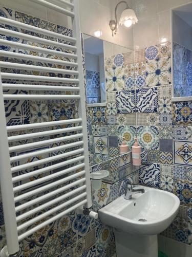 uma casa de banho com lavatório e azulejos azuis e brancos em Albergo Oasi em Nápoles