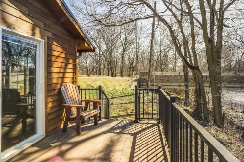 a porch of a house with a chair on it at Riverfront Covington Cabin with Deck and Fire Pit! in Piqua