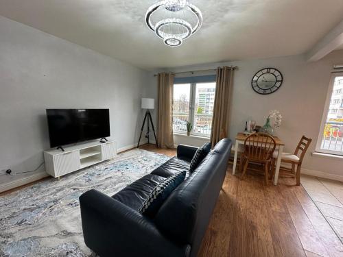 a living room with a couch and a tv at Modern Economy Glasgow Apartment with King bed in Glasgow