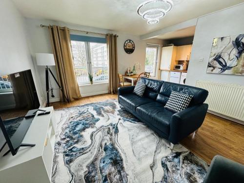 a living room with a black leather couch and a rug at Modern Economy Glasgow Apartment with King bed in Glasgow