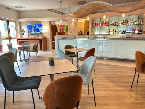 a restaurant with tables and chairs and a bar at Novotel Roma Est in Rome