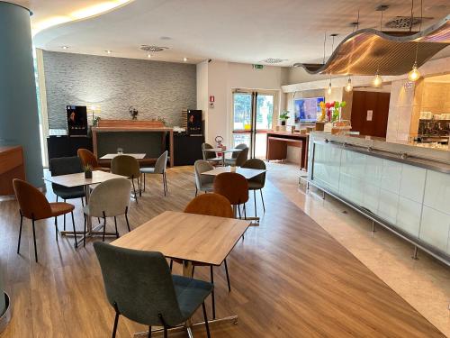 a restaurant with tables and chairs and a kitchen at Novotel Roma Est in Rome