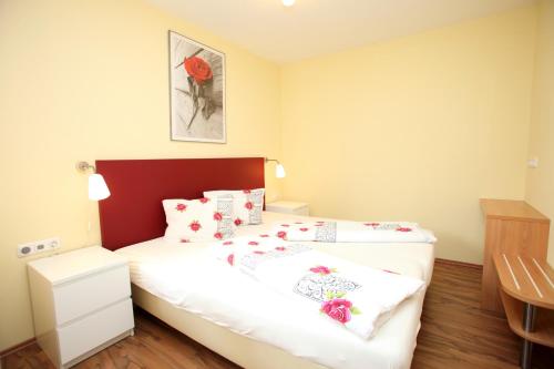 a small bedroom with a bed with flowers on it at Apartmenthaus Franz Kleindienst in Deutschlandsberg