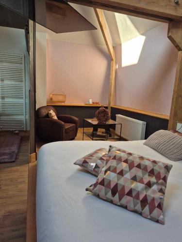 a bedroom with a bed and a chair and a couch at La Ferme de la Cour in Herbeumont