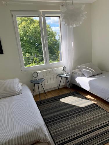 une chambre avec deux lits et deux fenêtres dans l'établissement Villa Séré de Rivières, au-dessus d'un fort, face aux Montagnes du Jura, à Fontain