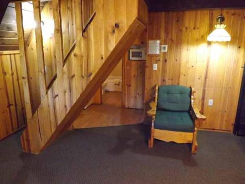 a room with a staircase and a green chair at Arizona Mountain Inn & Cabins in Flagstaff