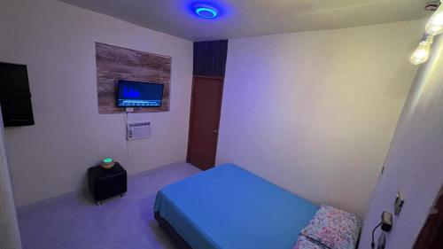 a room with a bed and a tv on a wall at cabañas zona verde tayrona in Santa Marta