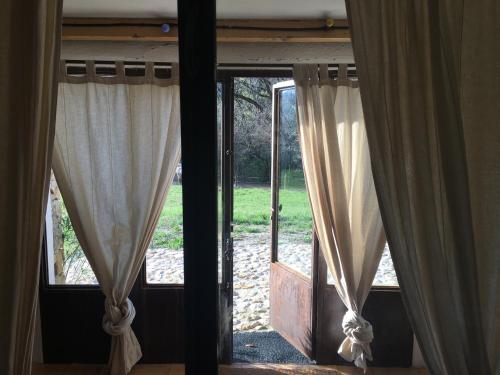 an open door with curtains in a room at Mymoustiers in Moustiers-Sainte-Marie