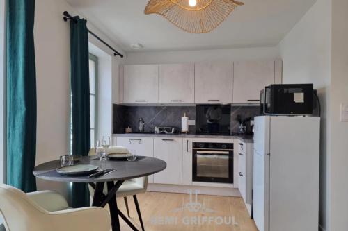 une petite cuisine avec une table et un réfrigérateur dans l'établissement L’Orée des Brumes Historic Center 2 people, à Honfleur