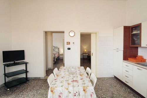 a dining room with a table and a kitchen at Casa vacanze LuGi by Apulia home in Torre San Giovanni Ugento
