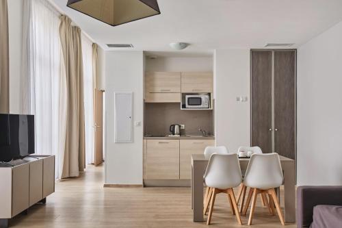 a kitchen and living room with a table and chairs at Appart Hotel Odalys City Montpellier Les Occitanes in Montpellier