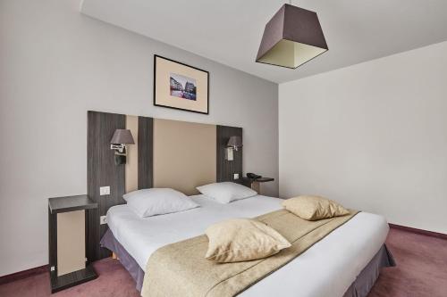 a bedroom with a large white bed with two pillows at Appart Hotel Odalys City Montpellier Les Occitanes in Montpellier