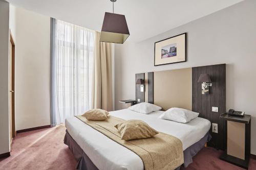 a hotel room with a large bed and a window at Appart Hotel Odalys City Montpellier Les Occitanes in Montpellier