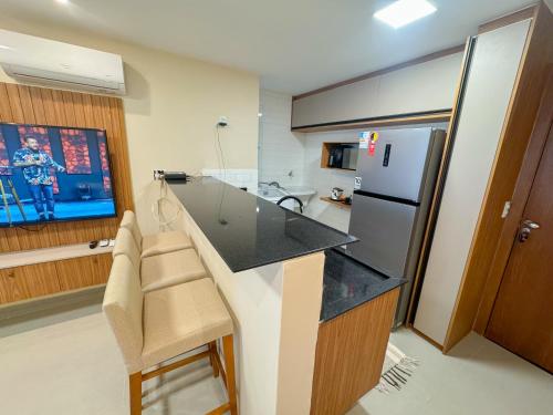 a kitchen with a large counter and a refrigerator at Apartamento 1 quarto Jardim da Penha in Vitória