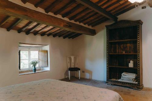 a bedroom with a bed and a window and a chair at Villa Bianca charming Tuscany house with pool in Lucca