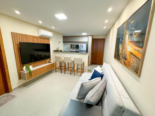 a living room with a couch and a kitchen at Apartamento 1 quarto Jardim da Penha in Vitória