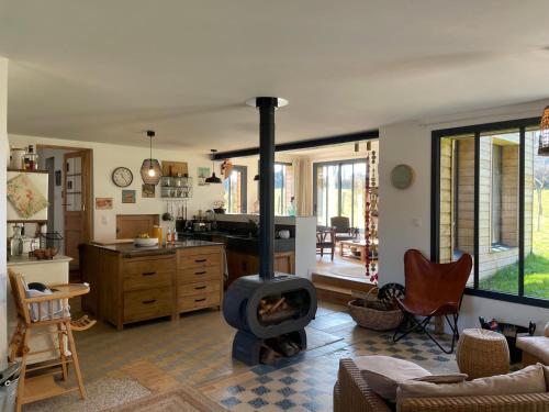 - une cuisine avec une cuisinière au milieu d'un salon dans l'établissement Le Shala Samarien - Maison Familiale, à Machiel