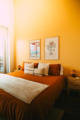 a bedroom with a large bed with orange walls at Penthouse - Luxe Stay with Views - Free Parking in Halifax