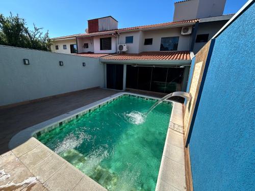 a swimming pool with a water fountain on a house at Sobrado, 4 Quartos, Piscina, até 12 pessoas in Foz do Iguaçu