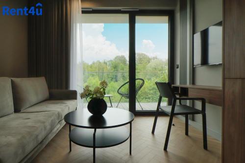 a living room with a couch and a table at Apartamenty Olimpijska by RENT4YOU in Olsztyn