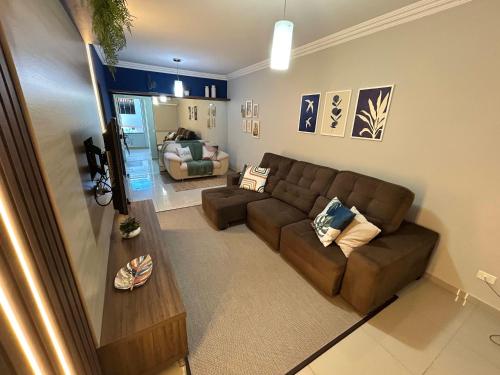 a living room with a brown couch and a table at Sobrado, 4 Quartos, Piscina, até 12 pessoas in Foz do Iguaçu