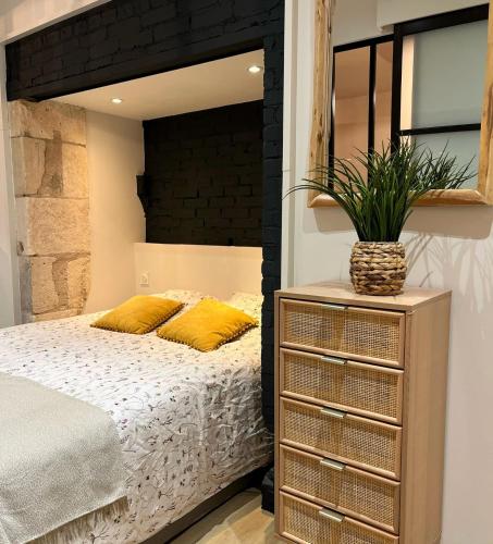 een slaapkamer met een groot bed met een zwart hoofdeinde bij La Suite des Arènes in Bourges