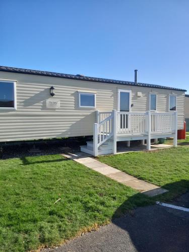 a mobile home with a porch and a yard at L90 HOLIDAY HOMe in Mablethorpe