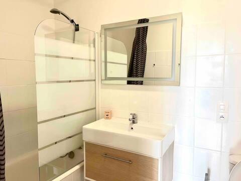 une salle de bain blanche avec un lavabo et un miroir dans l'établissement M20 Marquer Superbe t2 Gare Annemasse, à Annemasse