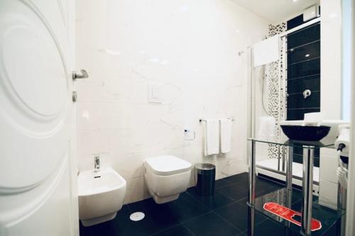 a white bathroom with a toilet and a sink at Les Suites Bari Italian Excellence Bed and Breakfast in Bari