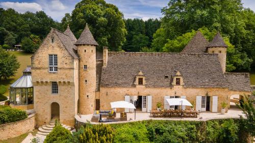 an old castle with tables and chairs in front of it at Château La Carrière in Saint-Cyprien