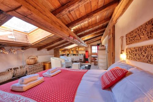 une chambre avec un grand lit dans une pièce avec des plafonds en bois dans l'établissement Chalet Foret Rouge, à Chamonix-Mont-Blanc