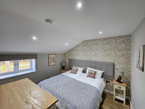 una camera da letto con un letto grande e una finestra di Bramley Suite - The Apple Barn a Pettistree